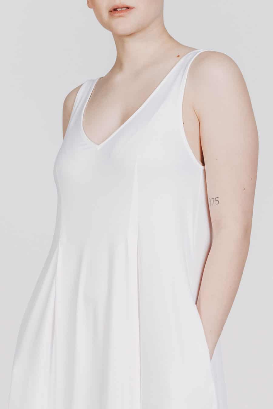 Deep White Black Modell SASHA langes Kleid weiß, ärmelloses Sommerkleid mit V-Ausschnitt, Schriftzug 1001 Deep White, Ansicht Detail Ausschnitt von vorne
