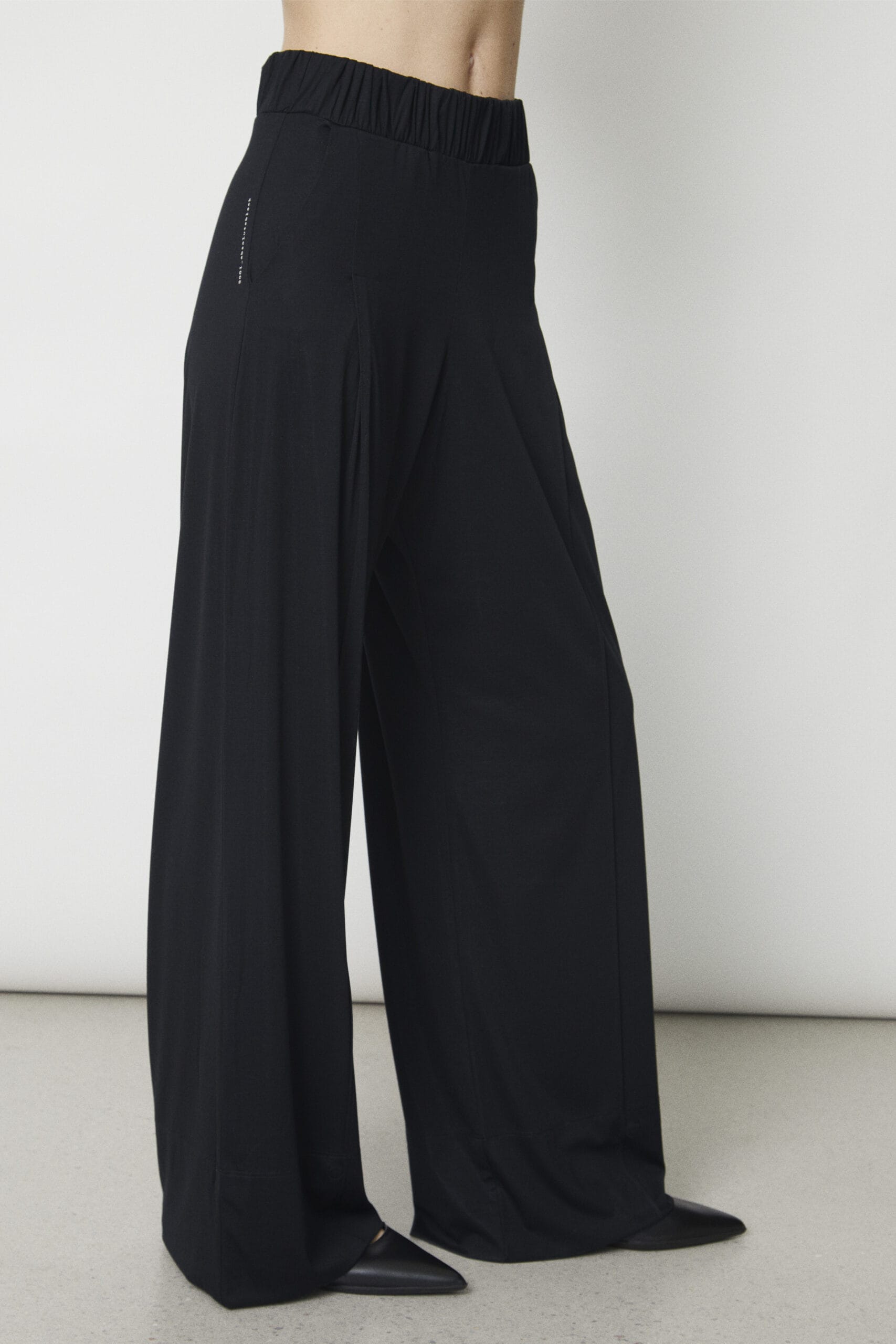 Deep White Black Modell ZOE weite Damen Hose schwarz mit Bügelfalte, Damen Stoffhose Schwarz aus Viscose mit elastischem Bund, versteckter Magnetknopf geöffnet, Ansicht von vorne rechts